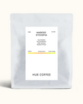 A matte silver coffee bag with a white label reading 'HADESO ETHIOPIA' and 'HUE COFFEE' on a light cream background.